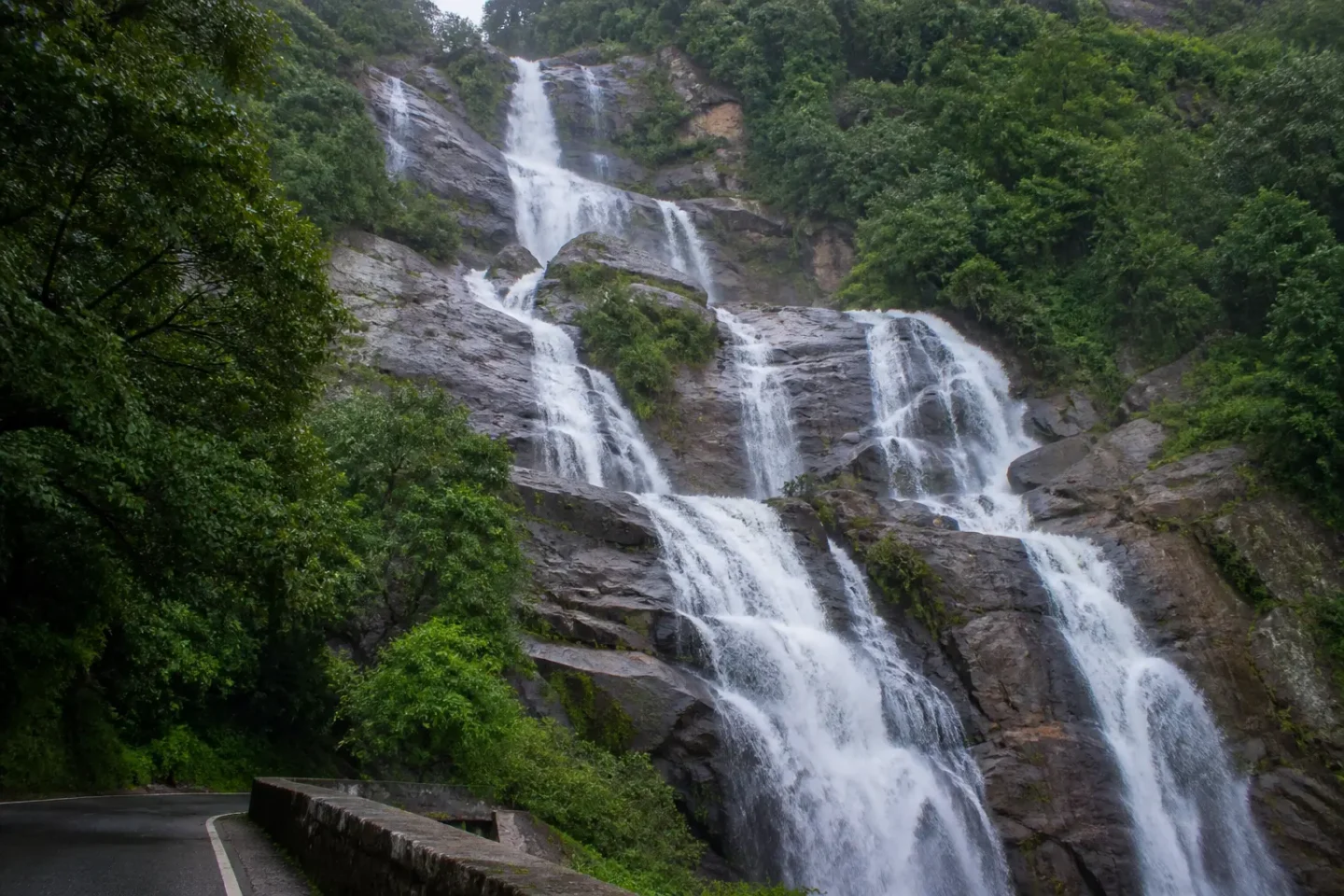 AI-generated illustration of Ravana Falls cascading beside the hill road